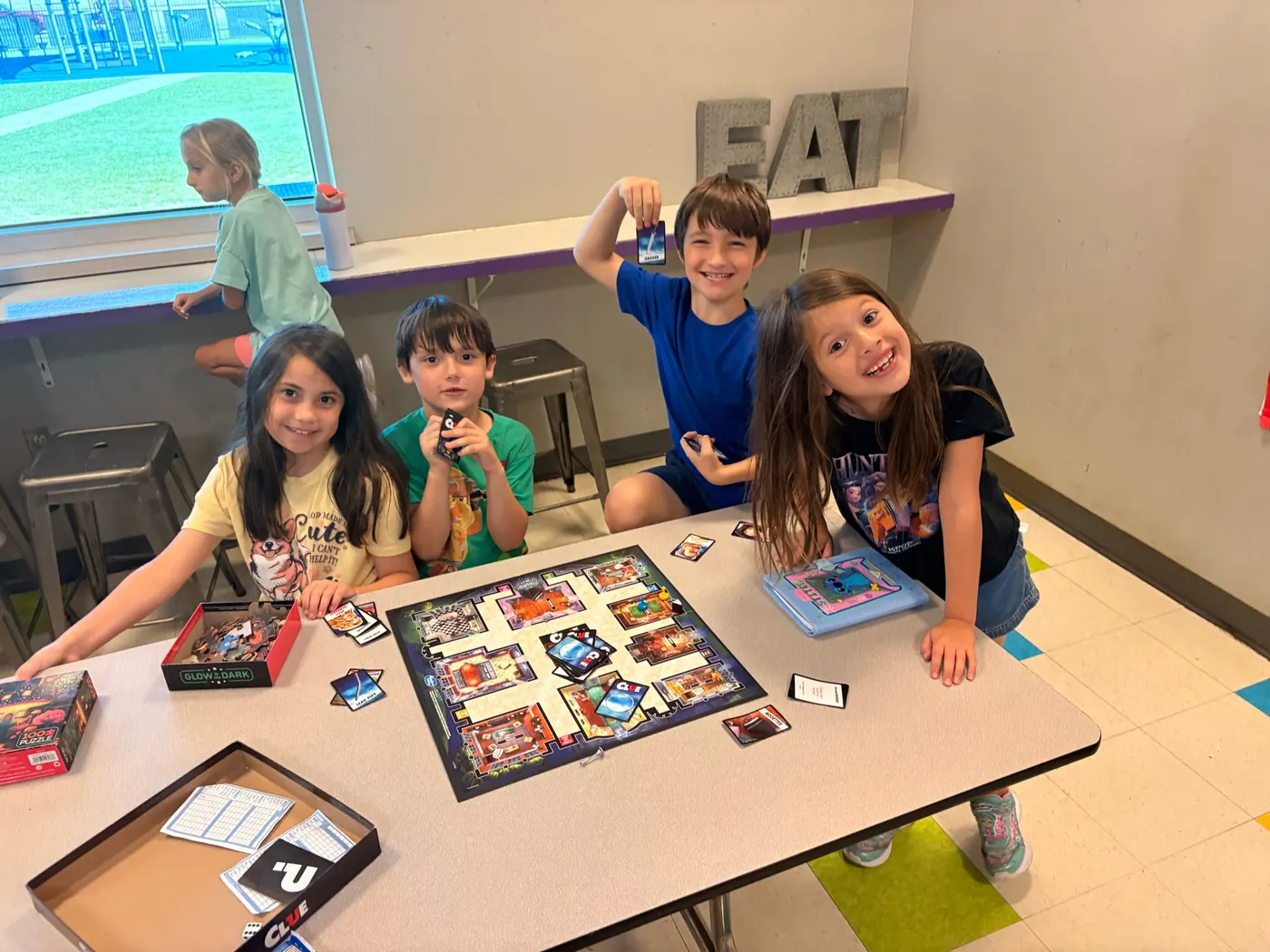 Children laughing over a board game in the Bryant Youth Association after school program in Bryant, AR
