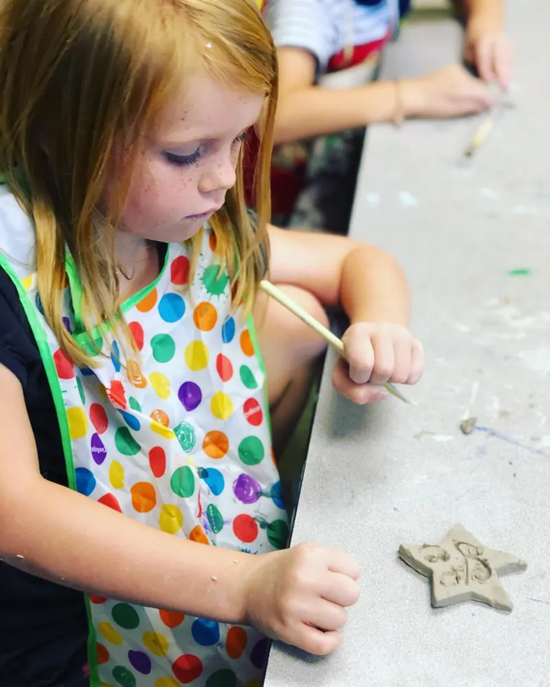 Girl shaping clay in an art class at the Bryant Youth Association after school program in Bryant, AR